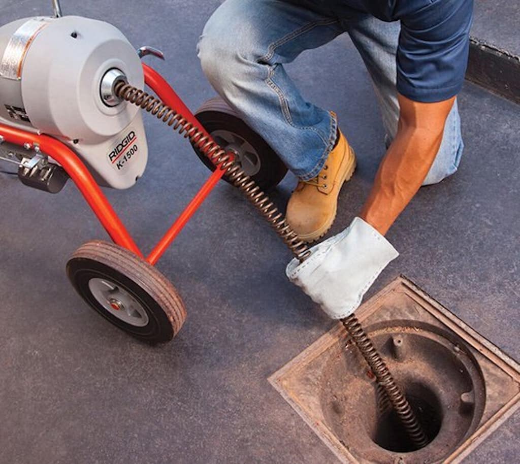 a plumber cleaning a drain